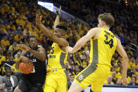 Butler's Kamar Baldwin drives to the basket against Marquette's Koby McEwen (25) and Jayce Johnson (34) during the second half of an NCAA college basketball game Sunday, Feb. 9, 2020, in Milwaukee. (AP Photo/Aaron Gash)