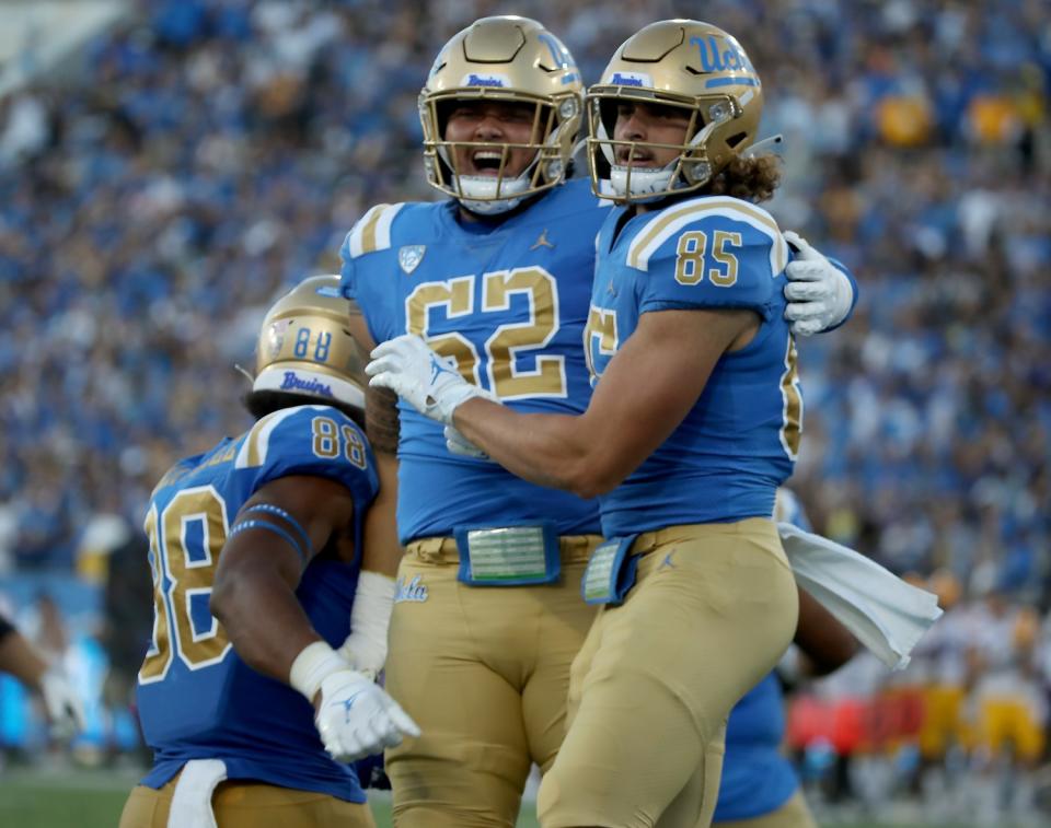 UCLA tight end Greg Dulcich (85) is congratulated by offensive lineman Duke Clemens (62) after scoring a second-quarter TD.