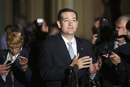 Reporters gather around U.S. Senator Ted Cruz (R-TX) as he announces he will not filibuster as he talks to reporters after a Republican Senate caucus meeting at the U.S. Capitol in Washington, October 16, 2013. REUTERS/Jonathan Ernst