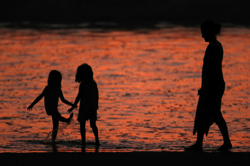 A family plays while cooling off at the beach in Cardiff after sunset during what local media reported to be a record breaking heat wave in Southern California, U.S., October 24, 2017. REUTERS/Mike Blake