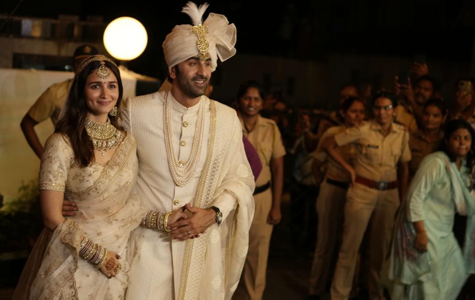 Bollywood actors Ranbir Kapoor and Alia Bhatt, left, pose for photographs after their wedding outside their residence in Mumbai, India, Thursday, April 14, 2022. (AP Photo/Rajanish Kakade)