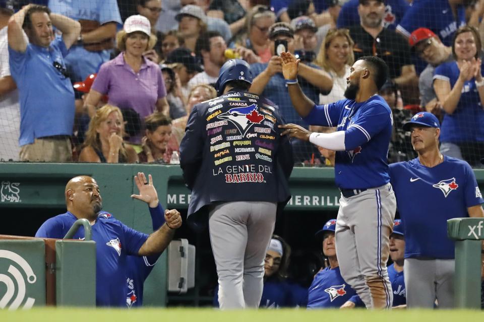 Toronto Blue Jays' Danny Jansen, center, celebrates his three-run home run with Teoscar Hernandez, right, during the fourth inning of the team's baseball game against the Boston Red Sox, Friday, July 22, 2022, in Boston. (AP Photo/Michael Dwyer)
