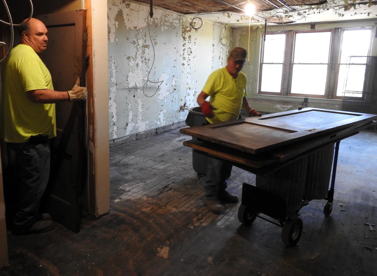 John Groves and Curt Kidd of Massillon Construction remove old doors from a second floor room in the old Chacos Building. It's being turned into the Coshocton Collaborative, a maker space and business incubator.