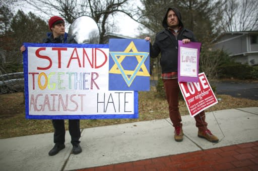 People hold signs of support near the house of Rabbi Chaim Rottenberg in Monsey, New York after the latest attack against Jewish targets