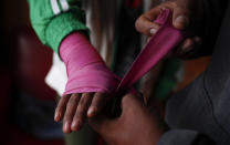 Gracce Kelly Flores is helped by her father to put bandages on her hand before starting his boxing training in Palca, Bolivia, Thursday, June 10, 2021. (AP Photo/Juan Karita)