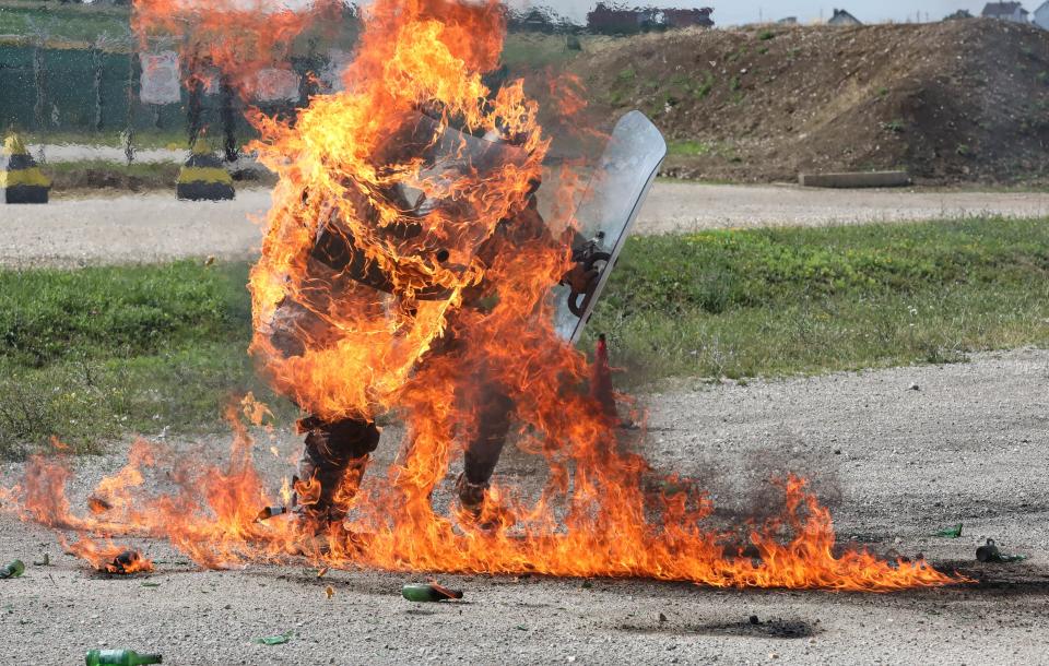 A photo of two soldiers holding riot shields engulfed in flames during fire phobia training in Germany.