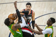 Portland Trail Blazers forward Robert Covington, center, and Utah Jazz center Derrick Favors, left, compete for possession of the ball during the first half of an NBA basketball game Thursday, April 8, 2021, in Salt Lake City. (AP Photo/Isaac Hale)