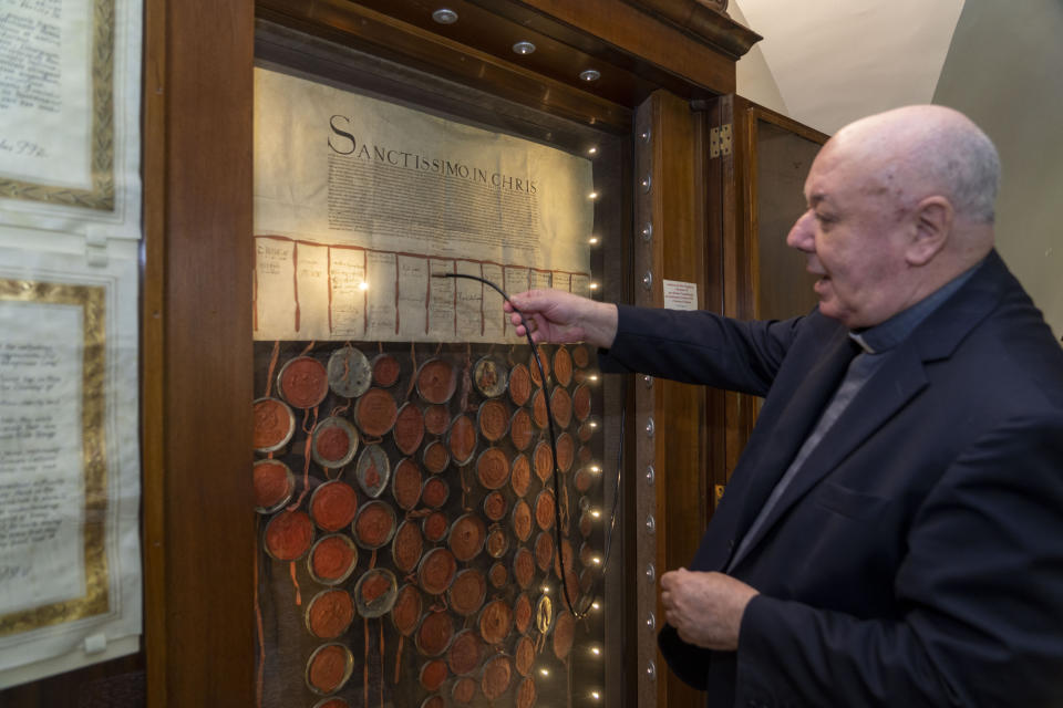 At the end of an interview with The Associated Press, Prefect of the Archivio Apostolico Vaticano, Bishop Sergio Pagano shows the original 1530 letter kept in his office at The Vatican, Wednesday, Feb. 14, 2024, and signed and sealed by the overwhelming majority of the House of Lords that attempted to pressure Pope Clement VII into granting the divorce to King Henry VIII of England from his wife Catherine of Aragon that was famously denied. Consequently, Henry VIII made himself the head of his church, free to divorce or marry whomever he pleased. In a new book-length interview with Italian journalist Massimo Franco, “Secretum”, Pagano divulges some of the unknown or behind-the-scenes details of well-known sagas of the Holy See and its relations with the outside world over the past 12 centuries. From Napoleon’s sacking of the archive in 1810 to the Galileo affair and the peculiar conclave of 1922 that was financed almost entirely by donations from U.S. Catholics. (AP Photo/Domenico Stinellis)