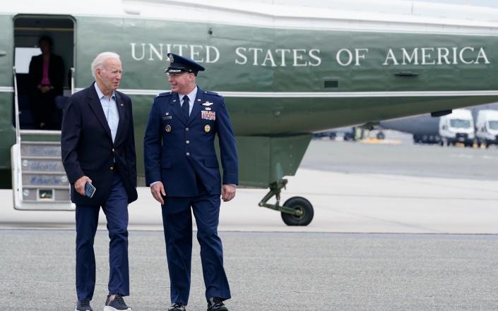 President Joe Biden, escorted by Col. William &quot;Chris&quot; McDonald, walks to board Air Force One