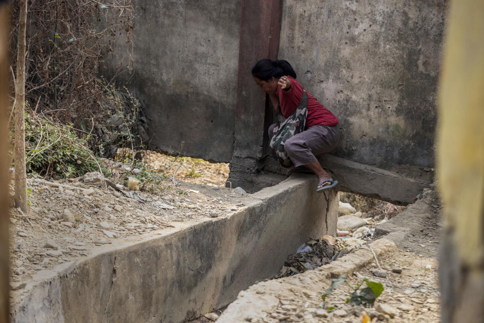 An unidentified woman used a drain hole to cross into Myanmar from the Champhai village in Mizoram, India, Saturday, March 20, 2021.Several Myanmar police officers who fled to India after defying army orders to shoot opponents of last month’s coup are urging Prime Minister Narendra Modi’s government to not repatriate them and provide them political asylum on humanitarian grounds. (AP Photo/Anupam Nath)