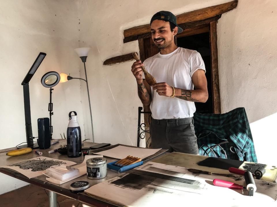 Printmaker Mario Alonso Perez holds the wooden spoon he often uses in the production of his prints.