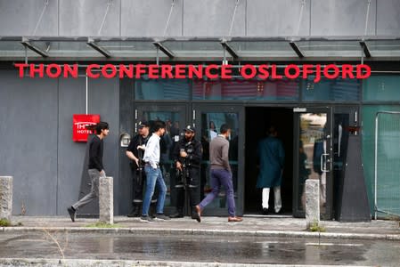 Armed police officers stand guard as Muslims from the Al-Noor mosque in Baerum arrive at the Thon hotel to attend the prayers during the first day of Eid al-Adha