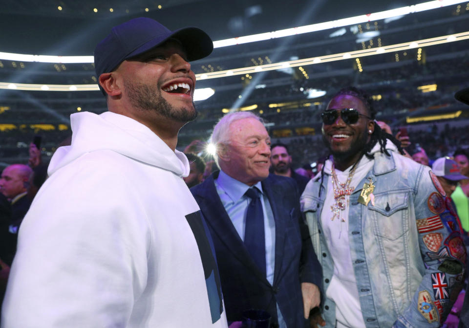 Dallas Cowboys quarterback Dak Prescott, left, team owner Jerry Jones, center, and defensive end DeMarcus Lawrence, right, visit before the main event between boxers Errol Spence Jr. and Mikey Garcia on Saturday, March 16, 2019, in Arlington, Texas. (AP Photo/Richard W. Rodriguez)