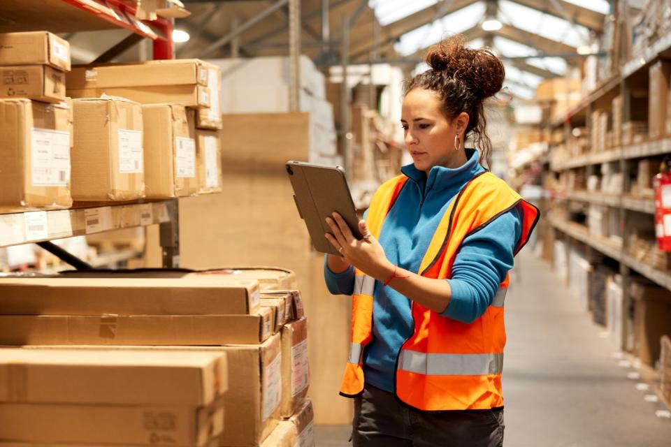 Worker in a warehouse using a tablet.