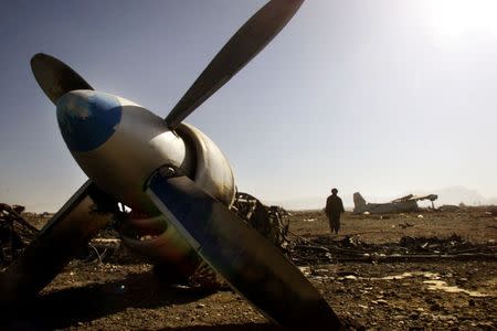 A Northern Alliance soldier walks among destroyed military planes as he inspects the wreckage at Kabul airport November 22, 2001. REUTERS/Damir Sagolj/Files