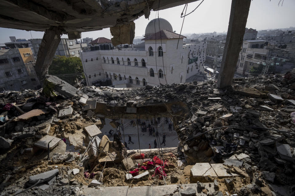 Palestinians look at a damaged residential building after an Israeli strike in Rafah, southern Gaza Strip, Wednesday, Jan. 10, 2024. (AP Photo/Fatima Shbair)