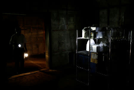 Kazuyuki Kitami, a city official of Yokosuka, holds a lantern and a flash light as he visits a facility which keeps the unclaimed burial urns containing ashes of the dead in Yokosuka, Japan September 11, 2018. Picture taken September 11, 2018. REUTERS/Kim Kyung-Hoon