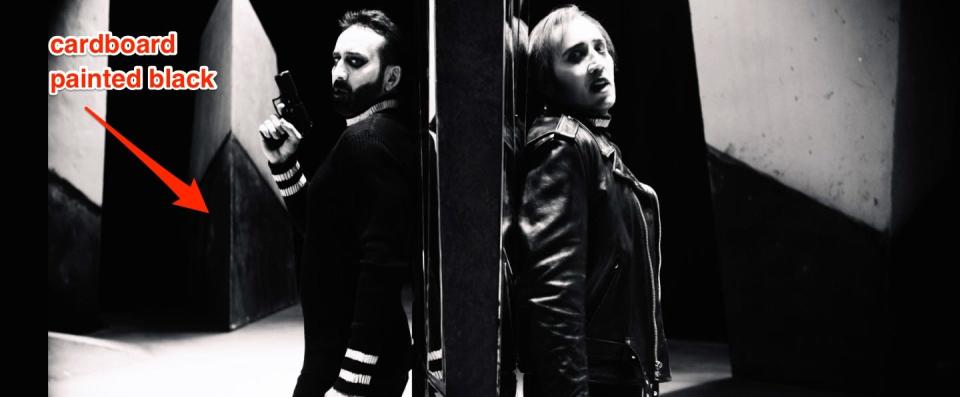 Nicolas Cage in black and white standing back-to-back with version of himself