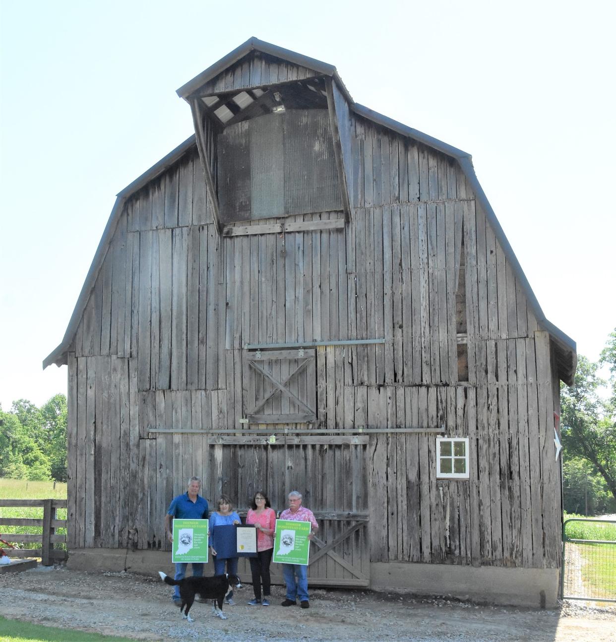 Jeff and Connie Sands and Mary and David Young pose with their Hoosier Homestead Awards in front of a barn on the property, built around 1932, by Connie and Mary's grandfather Forrest Jordan and their father Marion Jordan.