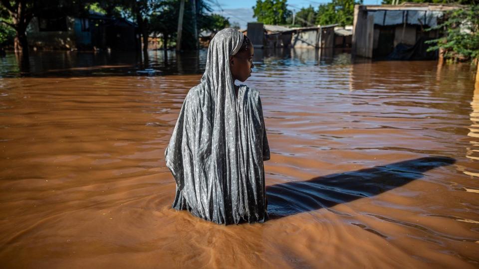 PHOTO: A woman wades through flood waters at an inundated residential area in Garissa, Kenya, on May 9, 2024 (Luis Tato/AFP via Getty Images)