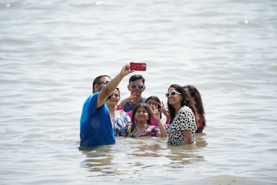 A man takes a family selfie in the water at Southend-on-Sea (Yui Mok/PA) (PA Wire)