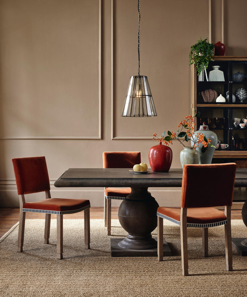 orange velvet dining chairs in a neutral dining room