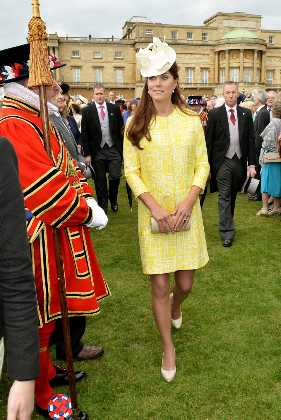 <p>Kate attended the Queen’s Garden Party in a sunny yellow dress from Emilia Wickstead. She carried a beige leather Russell & Bromley clutch and finished with a white hat from Jane Corbett. </p><p><i>[Photo: PA]</i></p>