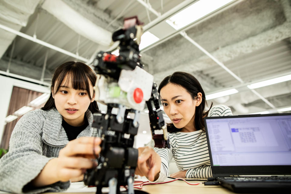 A female developer checks the operation of the robot.