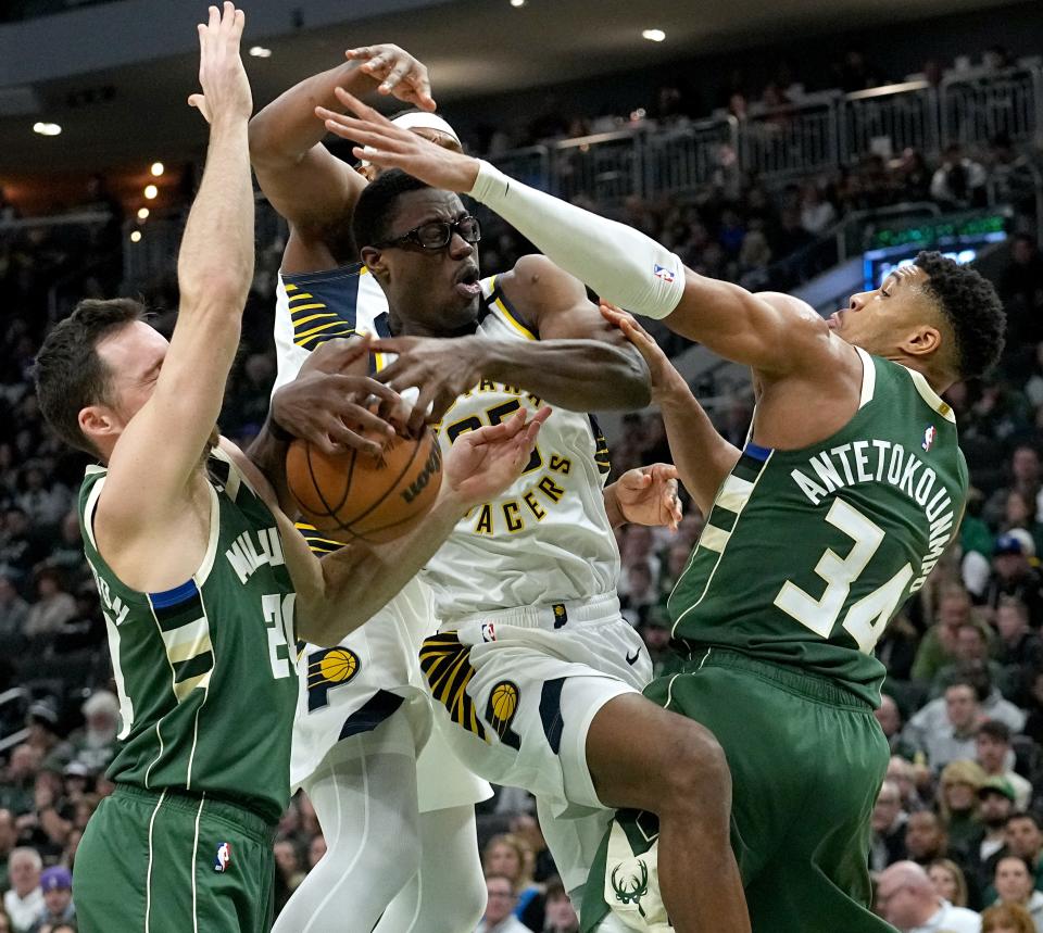 Pacers forward Jalen Smith is surrounded by Bucks players Pat Connaughton and Giannis Antetokounmpo during the first half Monday.