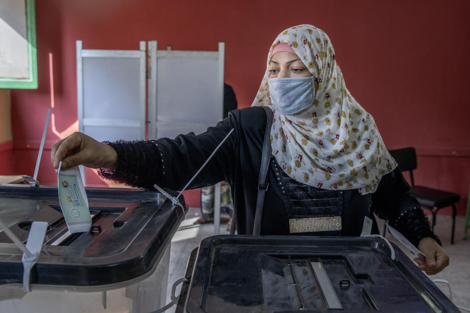 A woman casts her ballot on the first day of the parliamentary election inside a polling station in Giza, Egypt, Saturday, Oct. 24, 2020. Egyptians began voting Saturday in the first stage of a parliamentary election, a vote that is highly likely to produce a toothless House of Representatives packed with supporters of President Abdel-Fattah el-Sissi. (AP Photo/Nariman El-Mofty)