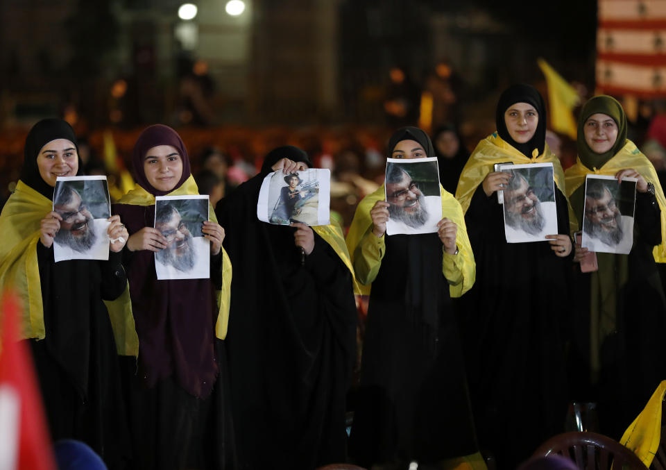 Hezbollah supporters hold portraits of Hezbollah leader Sayyed Hassan Nasrallah, during a rally marking the12th anniversary of the 2006 Israel-Hezbollah war, in Beirut, Lebanon, Tuesday, Aug. 14, 2018. The leader of Lebanon's militant Hezbollah group says U.S. sanctions against Iran and his group will not have major effects on them. (AP Photo/Hussein Malla)