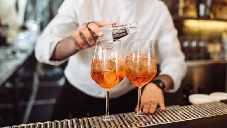 bartender pouring tonic into glasses