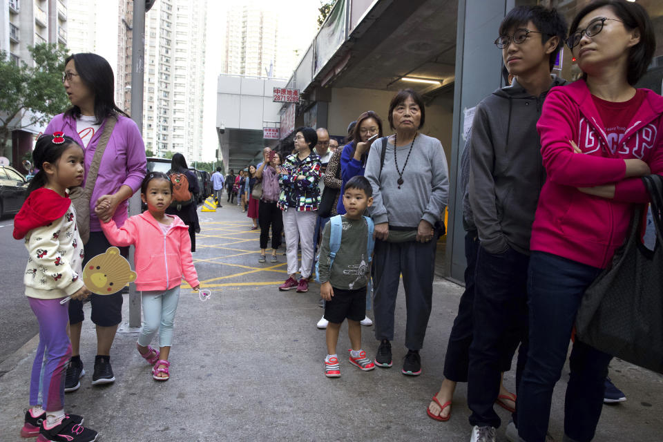 People line up to vote outside of a polling place in Hong Kong, Sunday, Nov. 24, 2019. Voting was underway Sunday in Hong Kong elections that have become a barometer of public support for anti-government protests now in their sixth month. (AP Photo/Ng Han Guan)