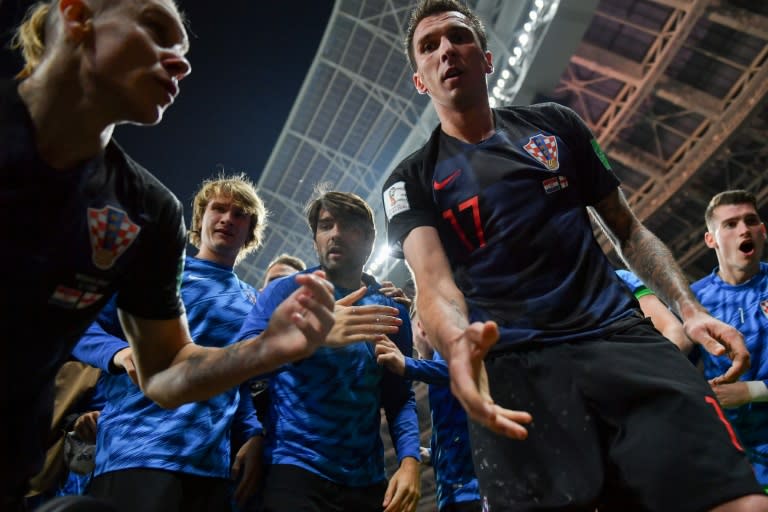 Hand it to Yuri! Croatia's Mario Mandzukic offers to help AFP photographer Yuri Cortez after he fell on him with teammates while celebrating their second goal against England