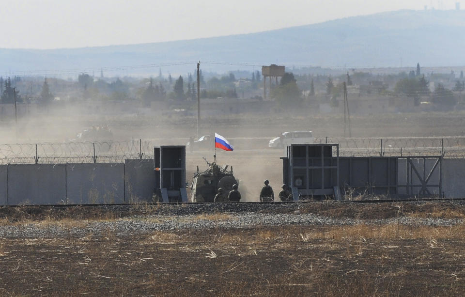 In this photo taken from the outskirts of Suruc, southeastern Turkey, a Russian army vehicle enters Syria, as it begins its joint patrol with Turkish forces, Tuesday, Nov. 5, 2019. Turkey and Russia launched joint patrols for the second time in northeastern Syria, under a deal that halted a Turkish offensive against Syrian Kurdish fighters who were forced to withdraw from the border area following Ankara's incursion. (AP Photo/Mehmet Guzel)