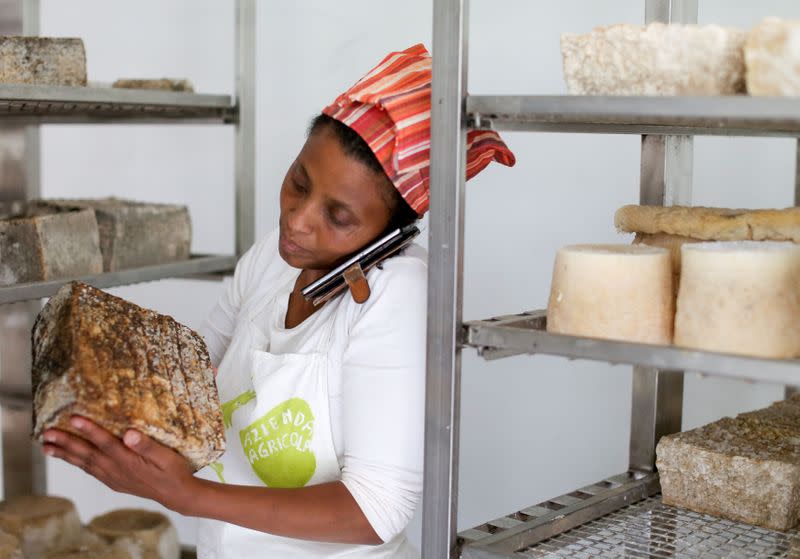 FILE PHOTO: Ethiopian Agitu Idea Gudeta, 40, talks on her mobile phone as she chooses a goat milk cheese for a client at her dairy farm at Valle dei Mocheni near Trento