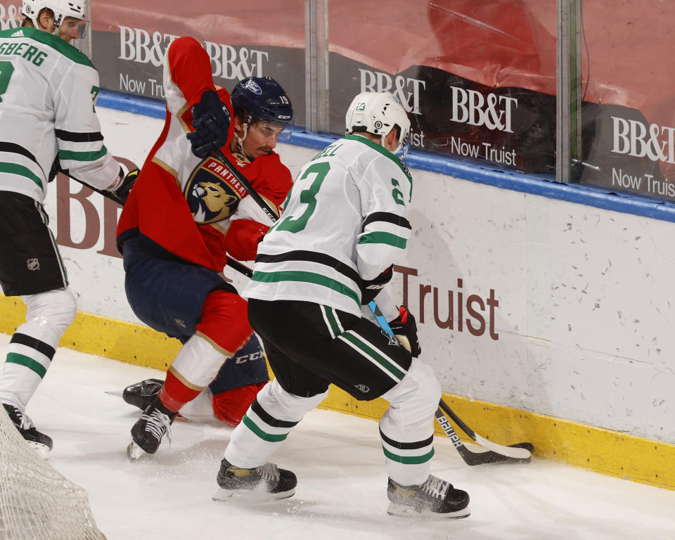 Florida Panthers left wing Mason Marchment (19) and Dallas Stars defenseman Esa Lindell (23) battle for control of the puck during the second period of an NHL hockey game, Monday, May 3, 2021, in Sunrise, Fla. (AP Photo/Joel Auerbach)