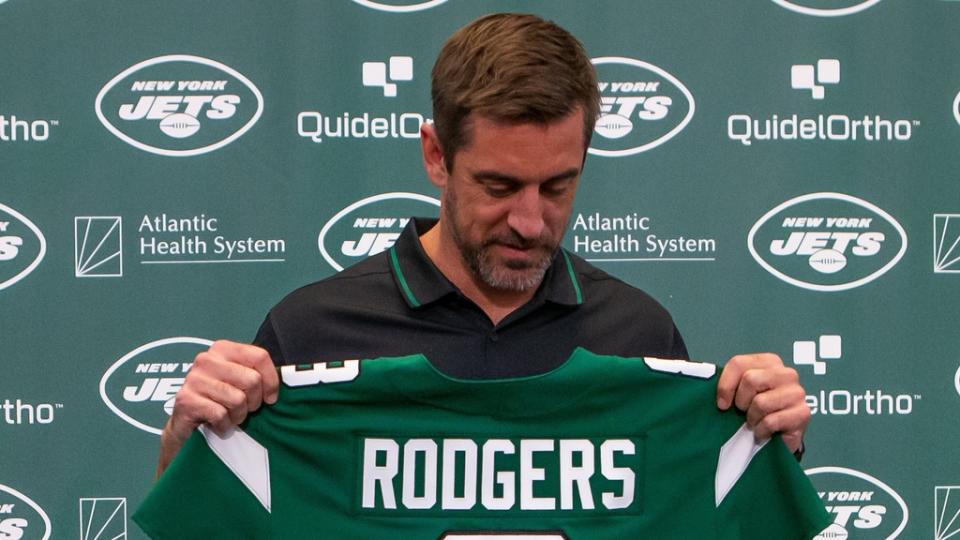 Aaron Rodgers looks down at his No. 8 Jets jersey during his introductory news conference.