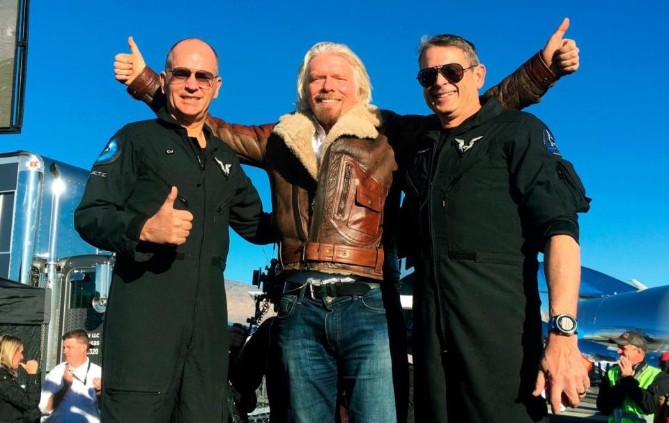 Richard Branson center celebrates with pilots Rick  Sturckow, left, and Mark Stucky, right