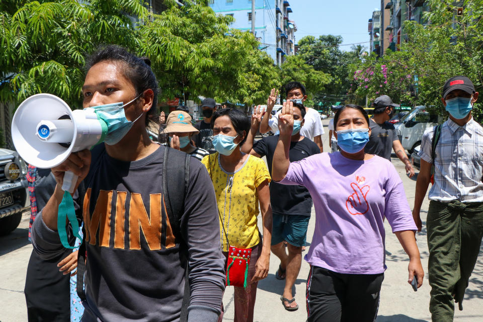 Young demonstrators flash the three-fingered symbol of resistance as they march in Yangon, Myanmar, Saturday, April 10, 2021. Security forces in Myanmar cracked down heavily again on anti-coup protesters Friday even as the military downplayed reports of state violence.(AP Photo)