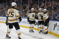 Boston Bruins' Jake DeBrusk (74) is congratulated by teammates Brandon Carlo (25), Trent Frederic (11) and Charlie Coyle (13) after scoring during the first period of an NHL hockey game against the St. Louis Blues Sunday, April 2, 2023, in St. Louis. (AP Photo/Jeff Roberson)