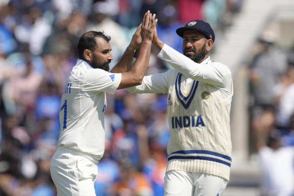 India's Mohammed Shami, left celebrates with India's Cheteshwar Pujara after taking the wicket of Australia's Cameron Green who was caught by India's Shubman Gill on the second day of the ICC World Test Championship Final between India and Australia at The Oval cricket ground in London, Thursday, June 8, 2023. (AP Photo/Kirsty Wigglesworth)