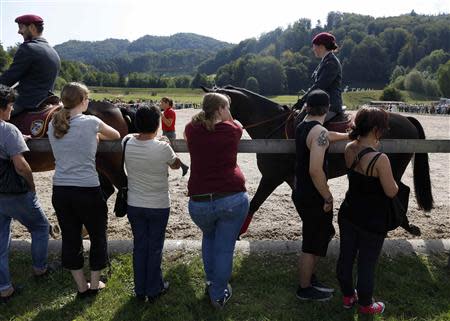 Family members and friends of recruits from the veterinary troops attend an official visiting day at a Swiss army base in Sand bei Schoehnbuehl, outside Bern September 7, 2013. REUTERS/Ruben Sprich