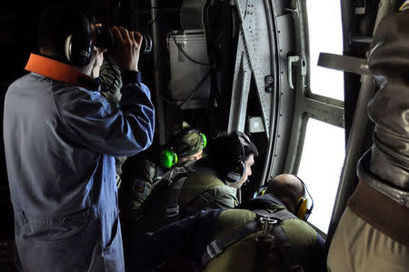 Members of the Argentine Navy look down at the sea from an airplane during a flight to search for the ARA San Juan submarine missing at sea, Argentina November 22, 2017. Argentine Navy/Handout via REUTERS ATTENTION EDITORS - THIS IMAGE WAS PROVIDED BY A THIRD PARTY.