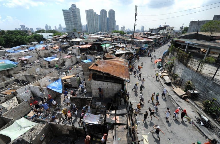 Squatters throw rocks at a demolition crew during a demolition in Manila's financial district on April 28, 2011. The Philippine government plans to move about 100,000 squatters from their homes on crucial waterways in Manila by June as a flood control measure and for their own safety
