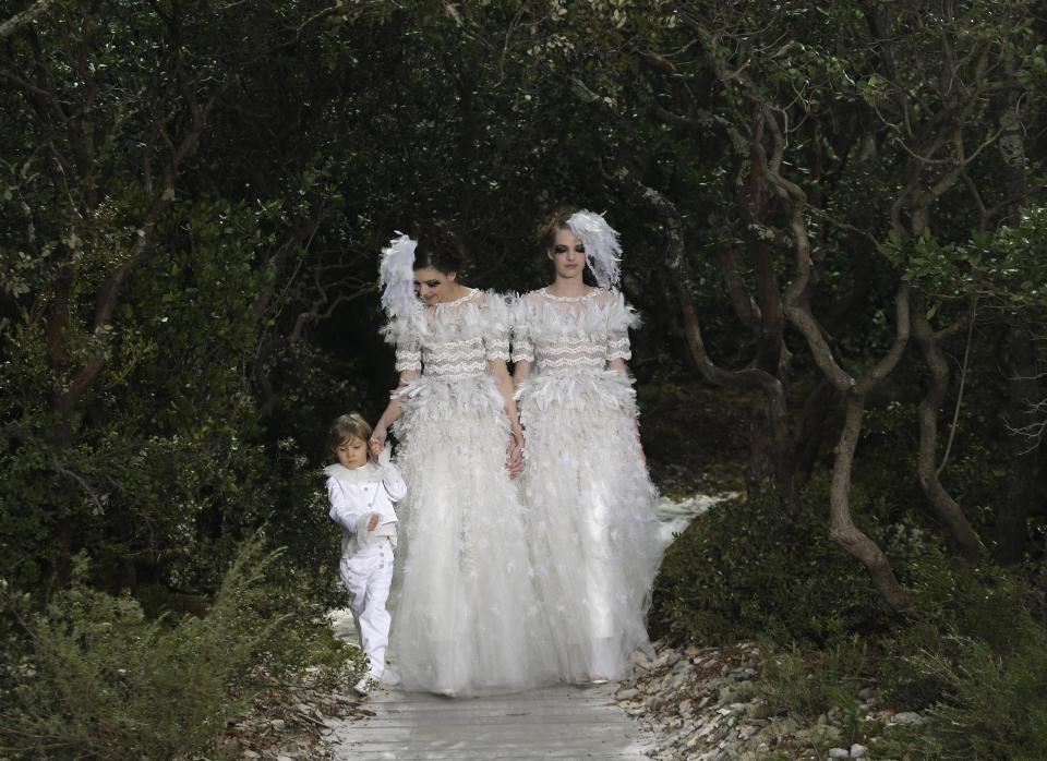 Models wear wedding gowns by German fashion designer Karl Lagerfeld for Chanel's Spring Summer 2013 Haute Couture fashion collection, presented in Paris, Tuesday, Jan.22, 2013. (AP Photo/Christophe Ena)