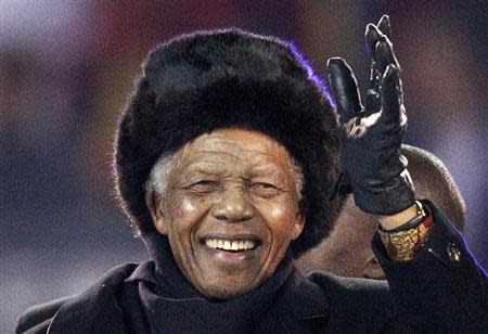 Former South African President Nelson Mandela waves to the crowd at Soccer City stadium during the closing ceremony for the 2010 World Cup in Johannesburg, in this July 11, 2010 file photo. REUTERS/Michael Kooren/Files