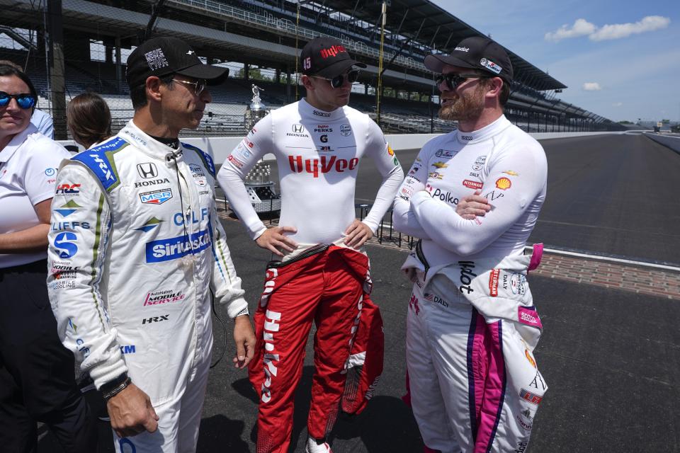 Helio Castroneves, from left, of Brazil, Christian Lundgaard, of Denmark, and Conor Daly talk before a practice session for the Indianapolis 500 auto race at Indianapolis Motor Speedway, Monday, May 20, 2024, in Indianapolis. (AP Photo/Darron Cummings)