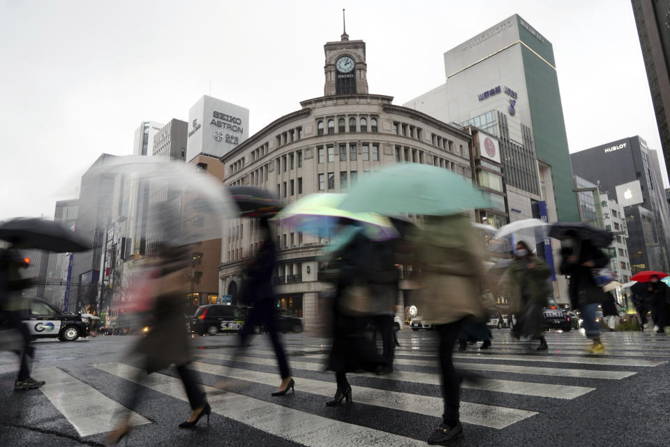 People walk on pedestrian crossing at Ginza shopping street Tuesday, Jan. 11, 2022, in Tokyo. (AP Photo/Eugene Hoshiko)