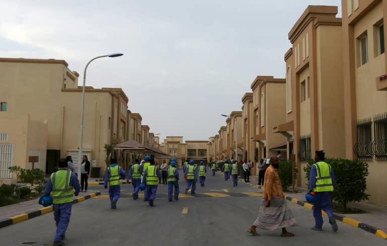 Foreign laborers working on the construction site of the al-Wakrah football stadium in Qatar walk back to their accomodation at the Ezdan 40 compound on May 4, 2015